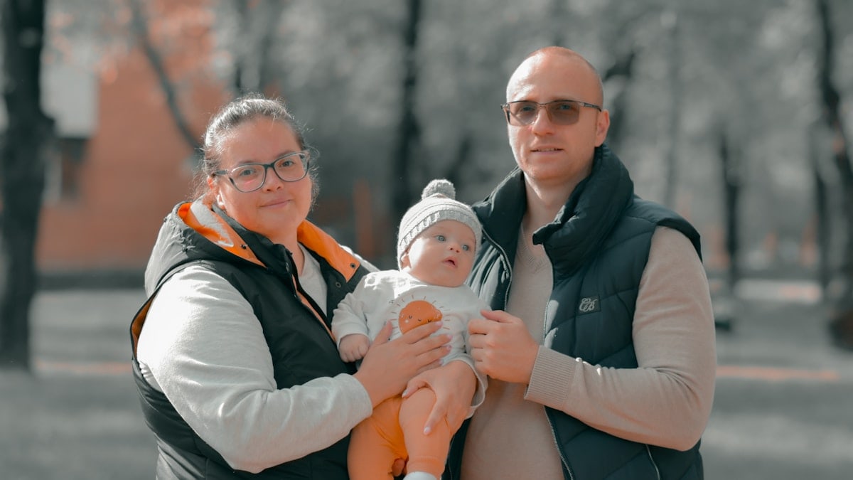a man and woman holding a baby